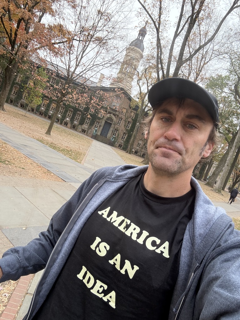 Jeff wearing an 'America is an idea' t-shirt in front of Nassau hall at Princeton